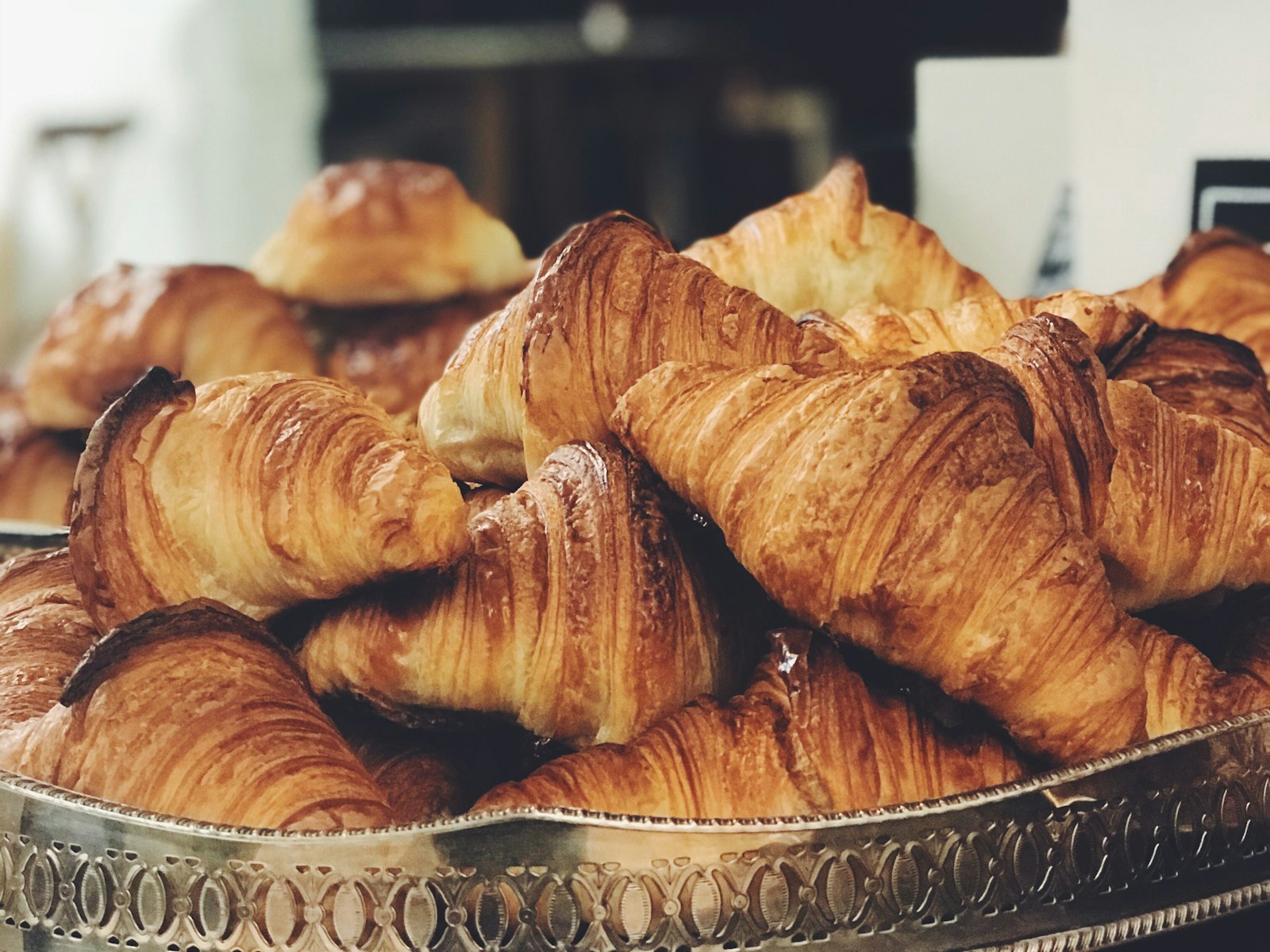 A pile of golden croissants on the counter