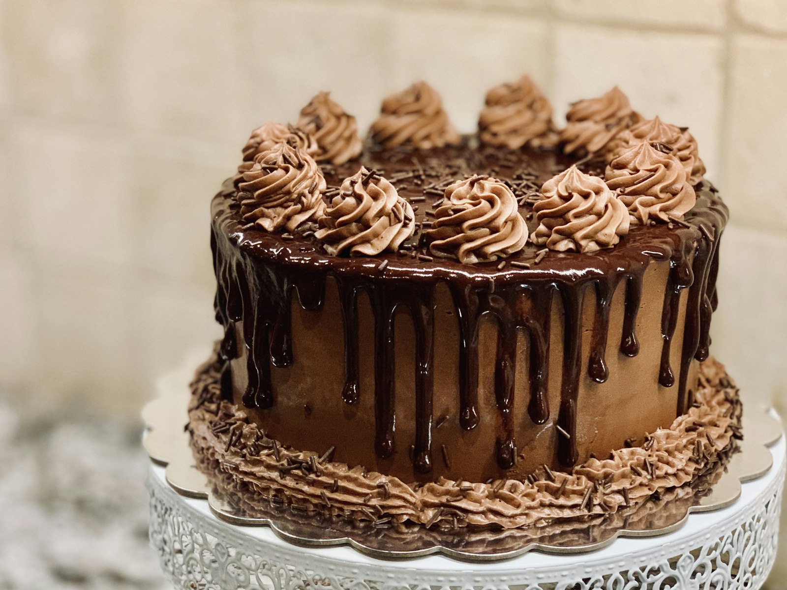 A chocolate cake with piped frosting and a chocolate drip